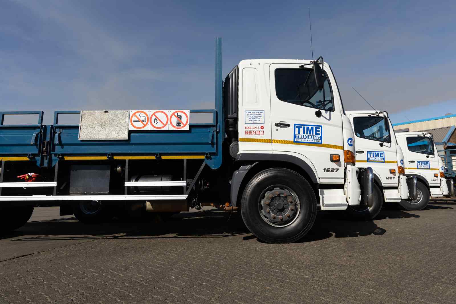 TIME Trucking flat-deck trucks parked in a row
