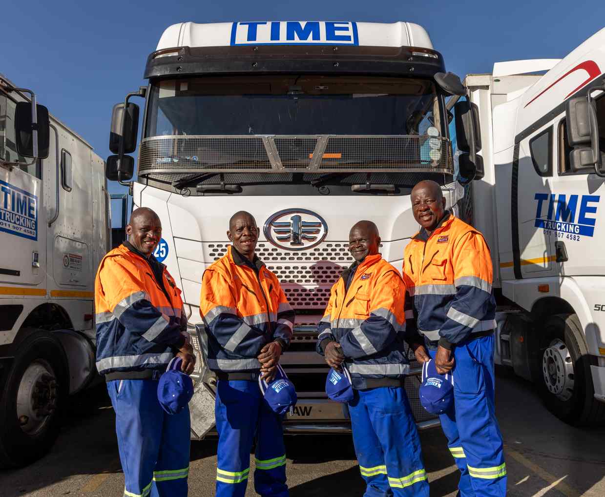 Time Trucking team members with a fleet vehicle